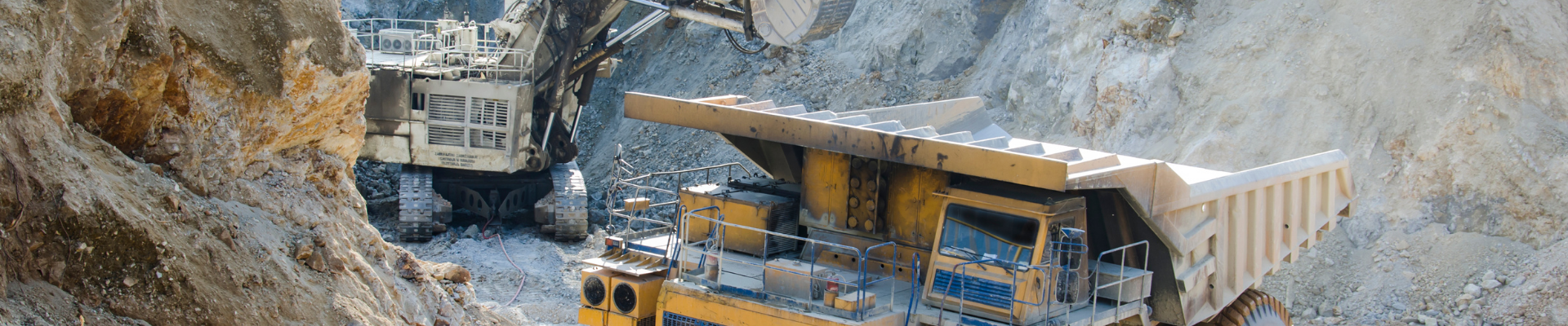 Aerial view of heavy excavation equipment and a mining haul truck at an open-pit mine, representing ProjectLink's project management solutions for the mining industry.
